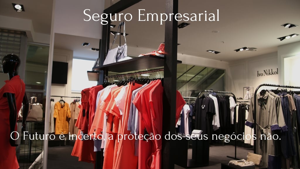 A imagem mostra a fachada de uma loja de roupas femininas, com grandes vitrines elegantes e iluminadas, refletindo sofisticação e bom gosto. A imagem simboliza a proteção e segurança oferecida pelo seguro empresarial. The image shows the facade of a women's clothing store, with large, elegant, illuminated windows, reflecting sophistication and good taste. The image symbolizes the protection and security offered by business insurance.