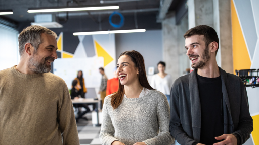 Imagem mostra um escritório com dois homens e uma mulher ao centro, saindo felizes e rindo, Image shows an office with two men and a woman in the center, leaving happy and laughing,